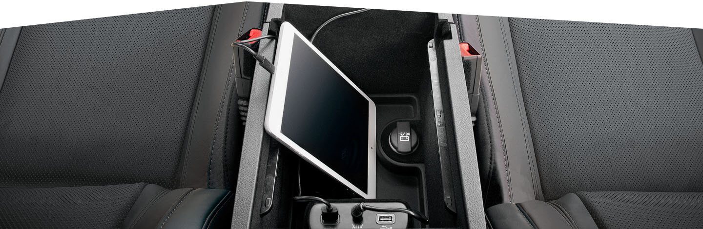 The center console in the 2020 Dodge Charger with a tablet and smartphone plugged into charging ports.